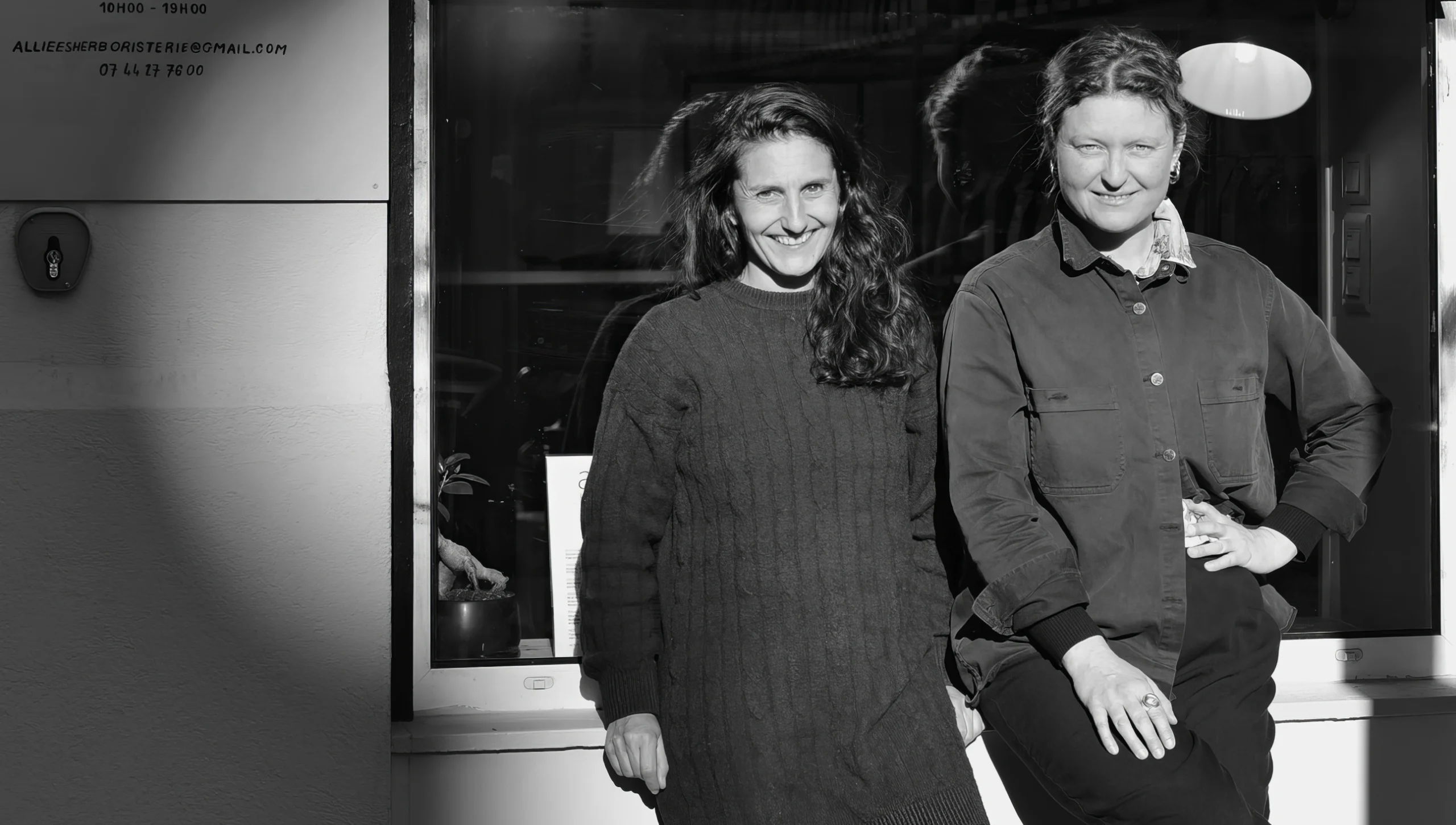 Portrait en noir et blanc des deux fondatrices devant l’herboristerie